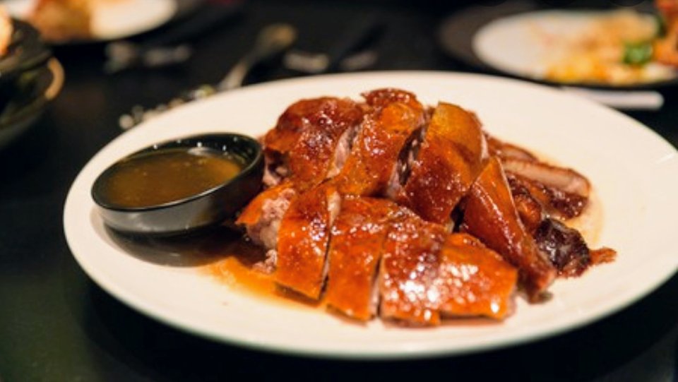 Chinese restaurant dishes on white plates.